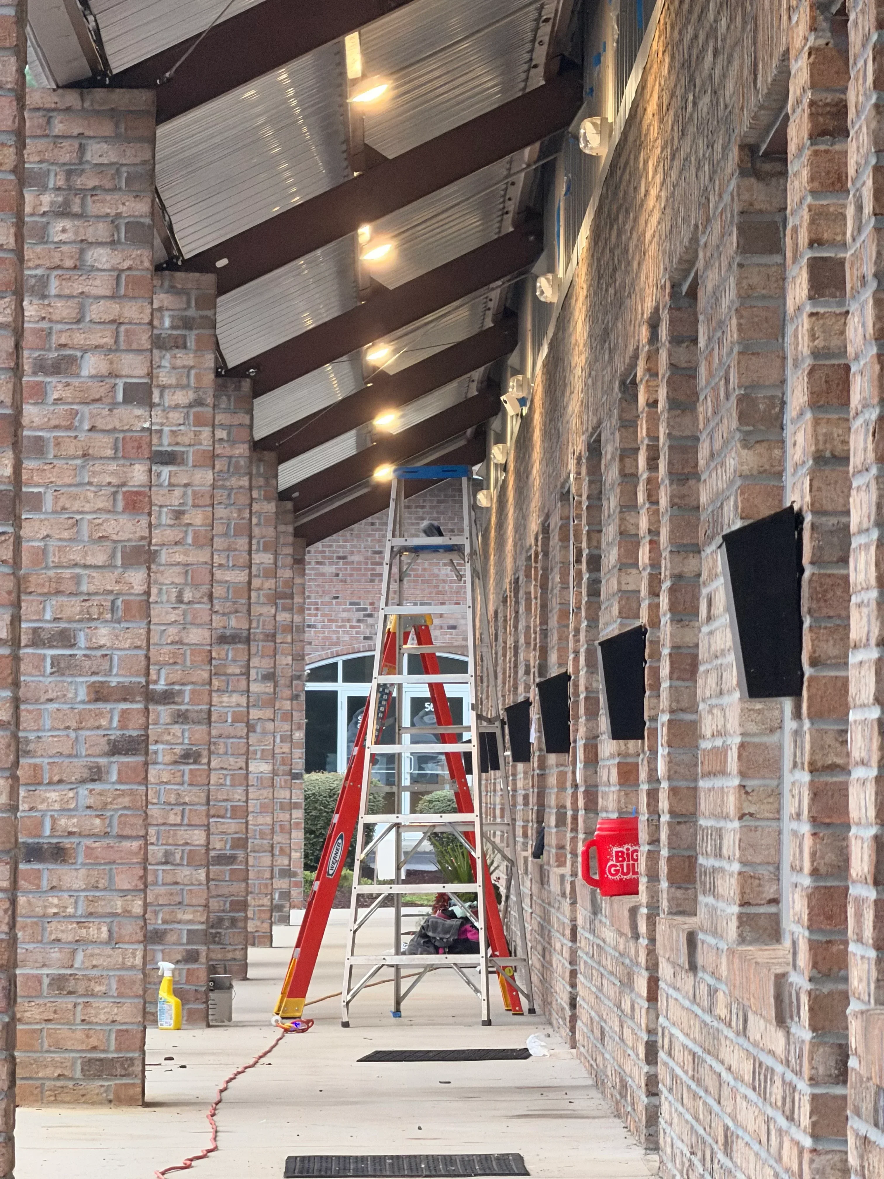 Brick storefront with metal awning frame, steel support beams, and structural bracing during renovation