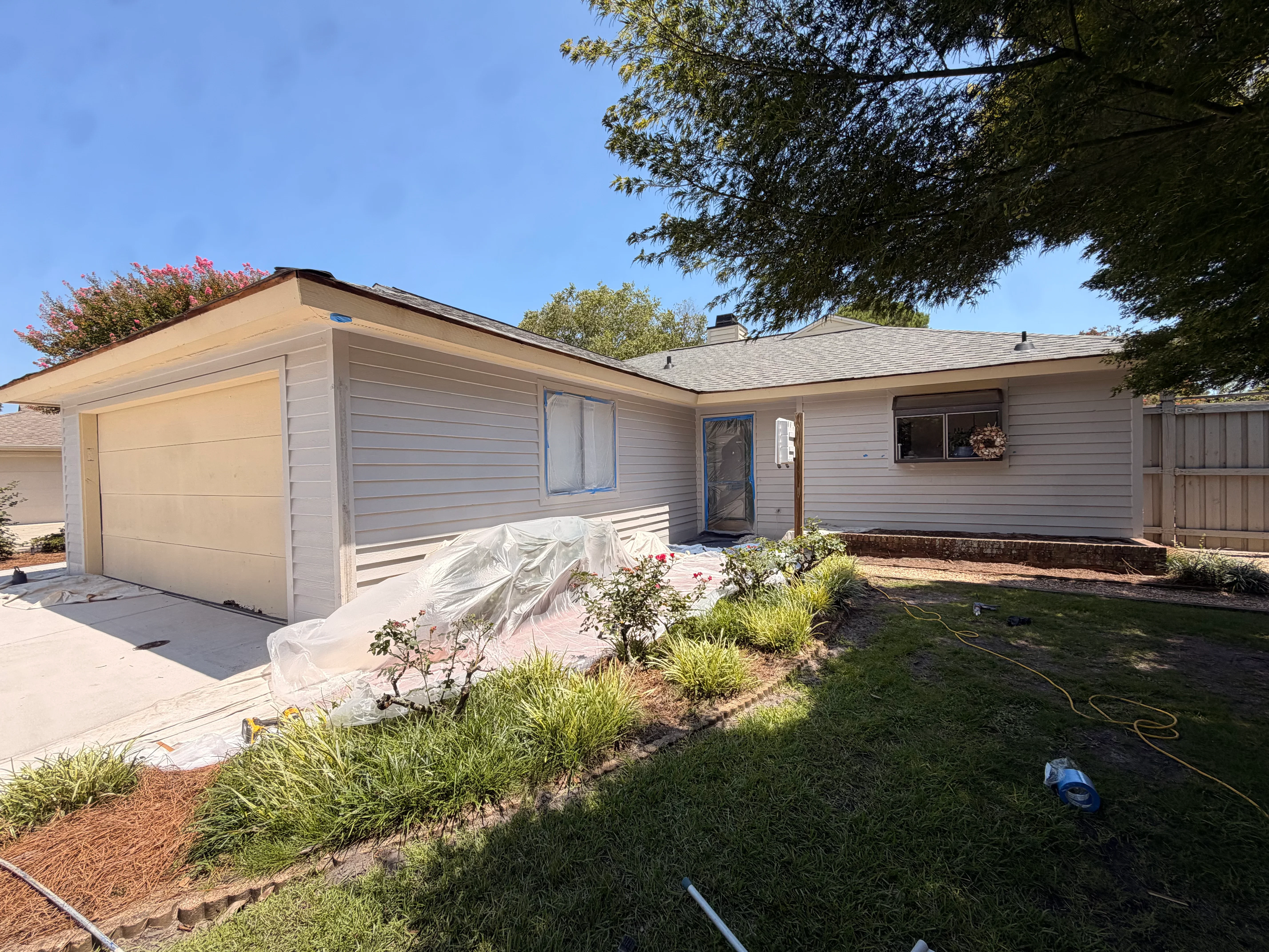 Light gray vinyl siding on single-story home with new garage door and fresh exterior trim