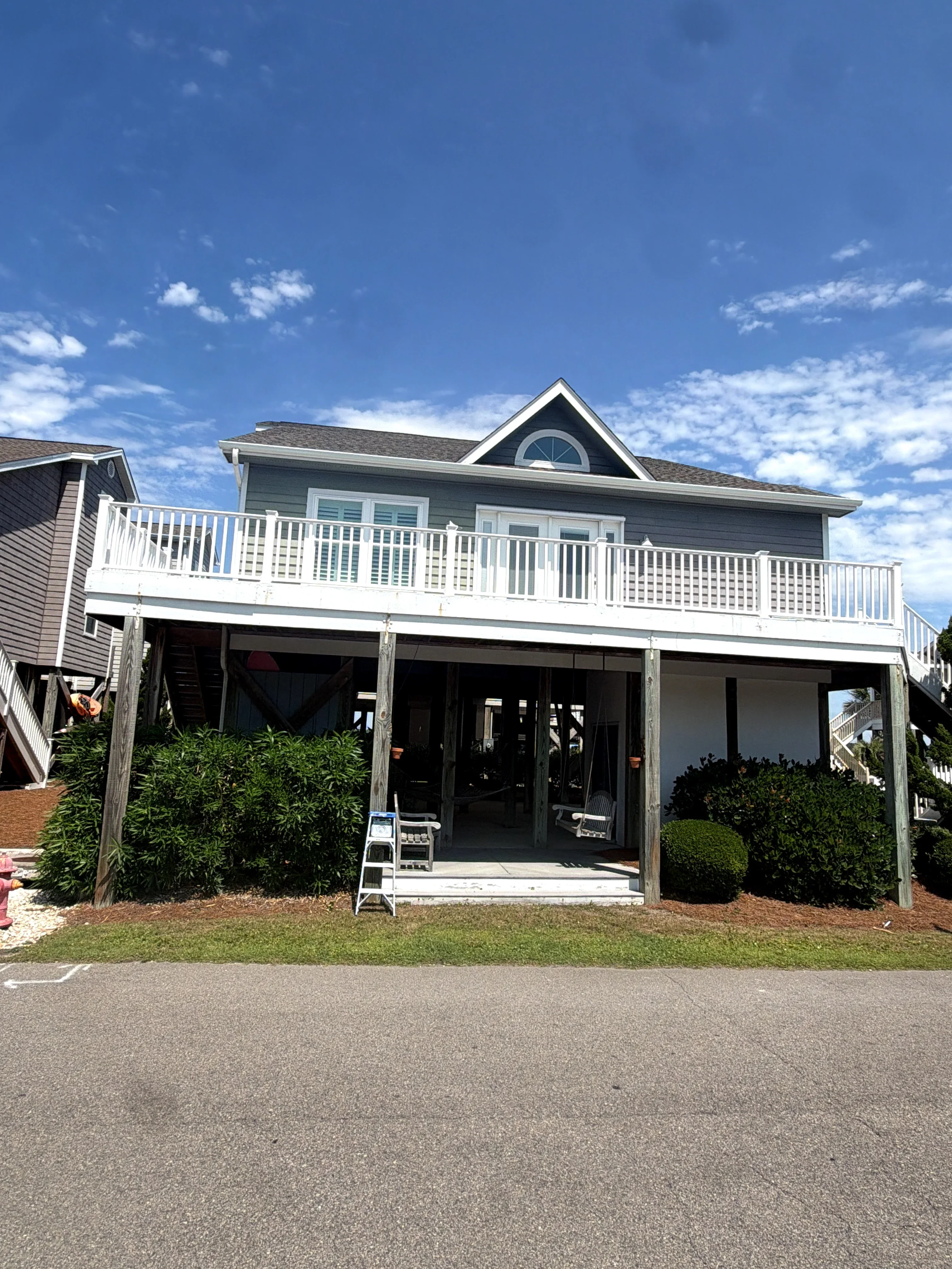 Elevated deck with white vinyl railings and balusters on residential home