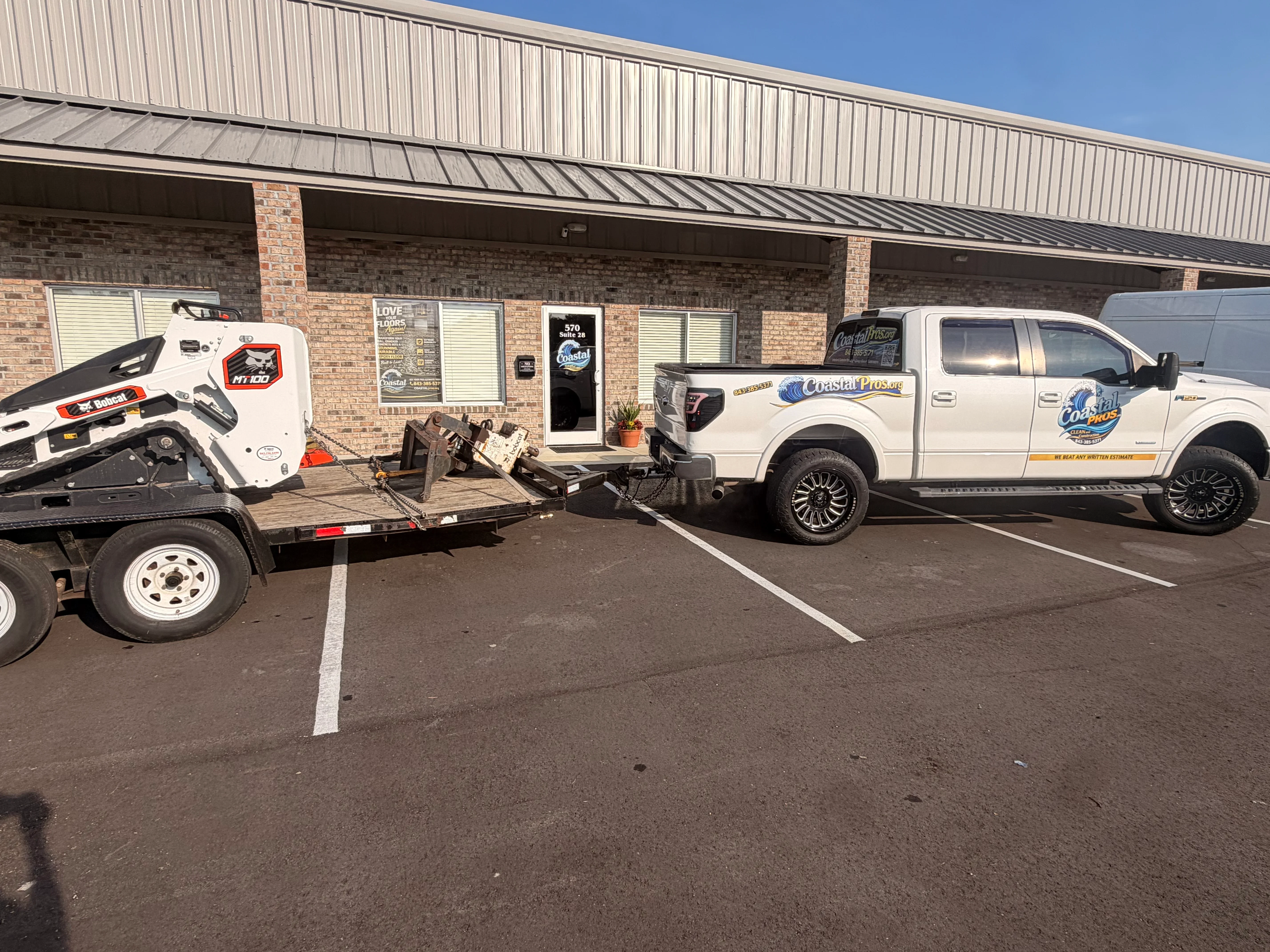 White pickup truck and equipment trailer with company branding and professional graphics