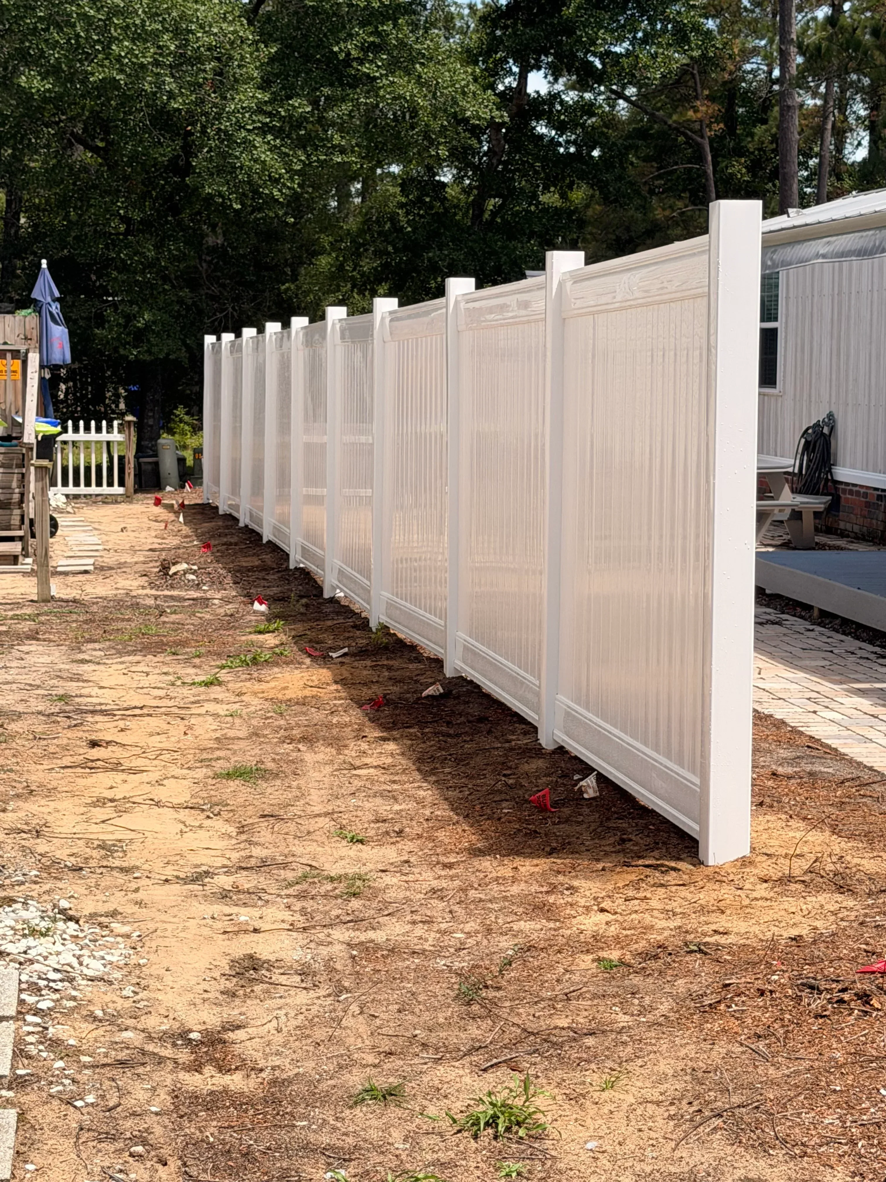 White polycarbonate patio cover with aluminum frame over dirt patio area