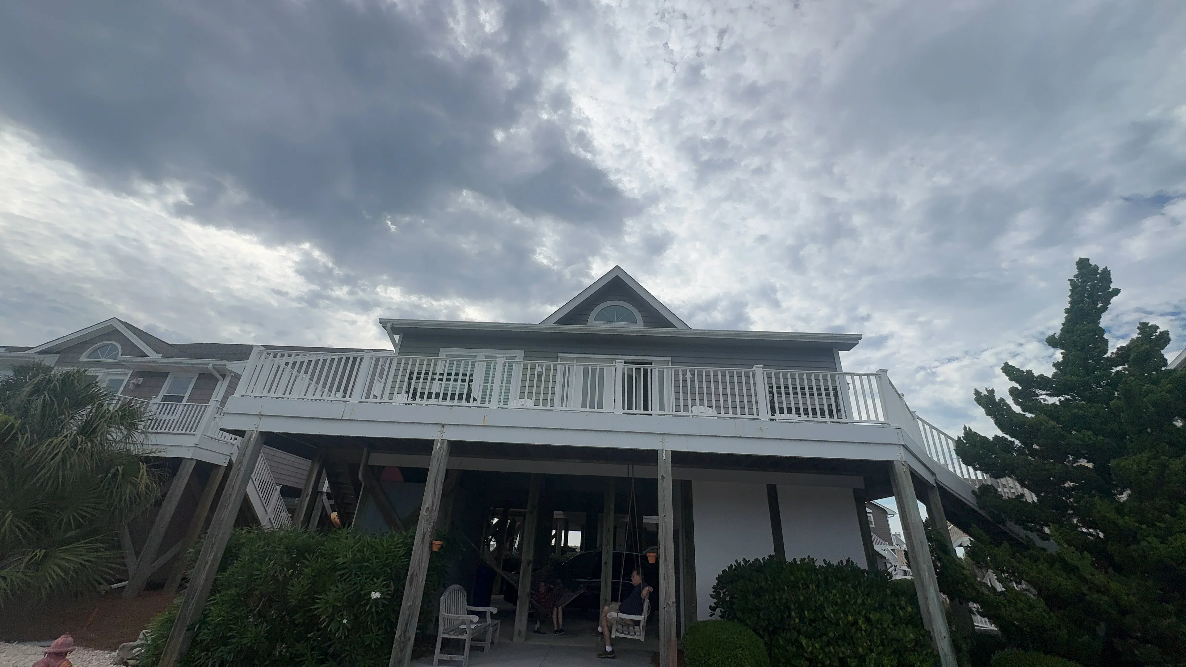 Elevated deck with white vinyl railings and balusters on coastal home